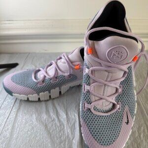 Nike women’s training sneakers in a lilac and grey colorway with bright orange